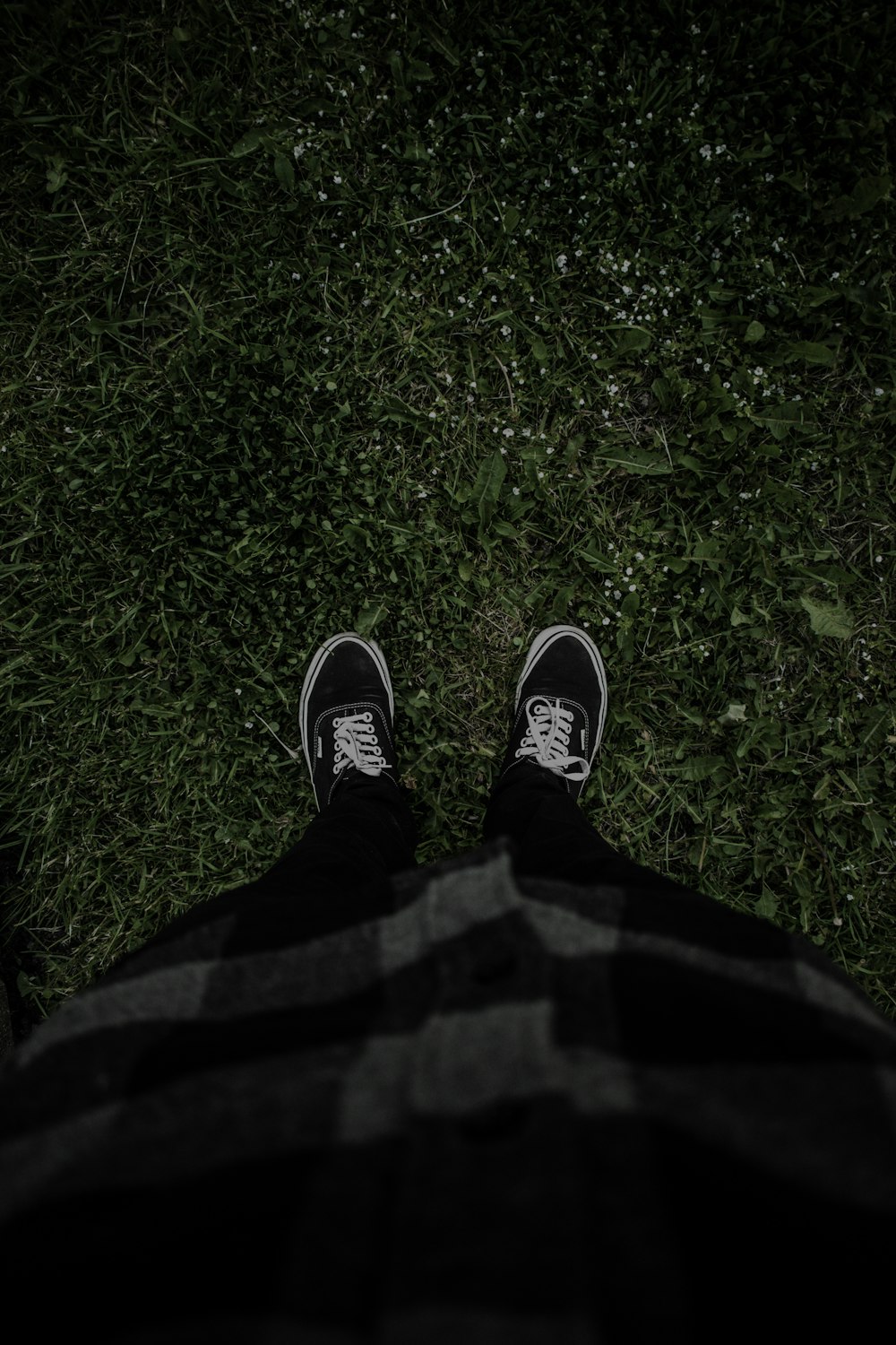 person in black pants and black and white sneakers