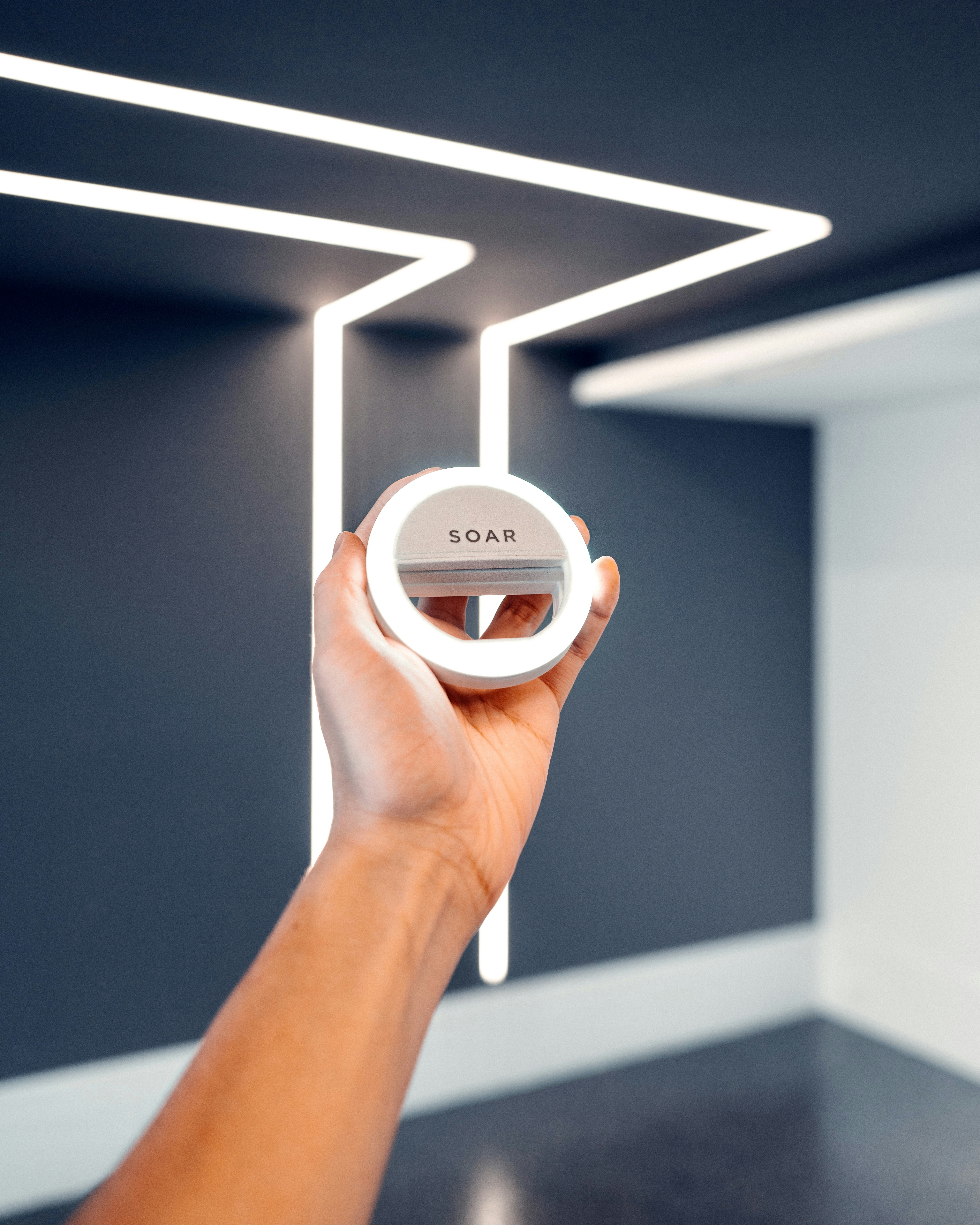 persona sosteniendo un dispositivo redondo blanco