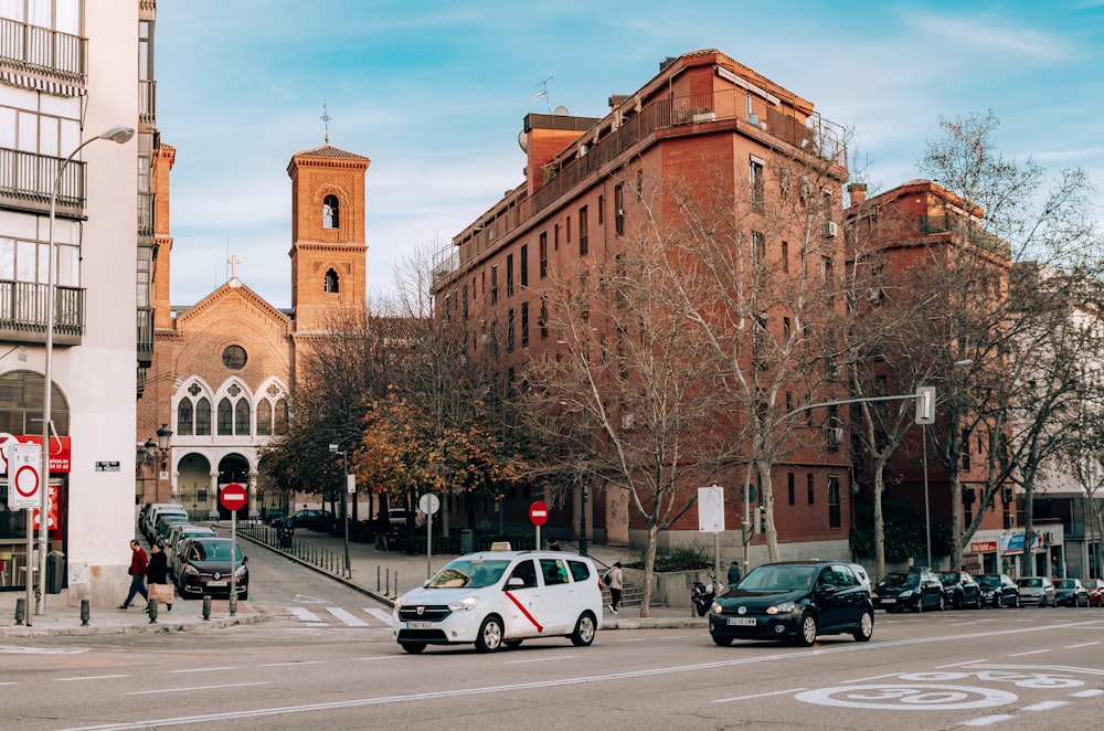 cars parked in front of brown concrete building during daytime