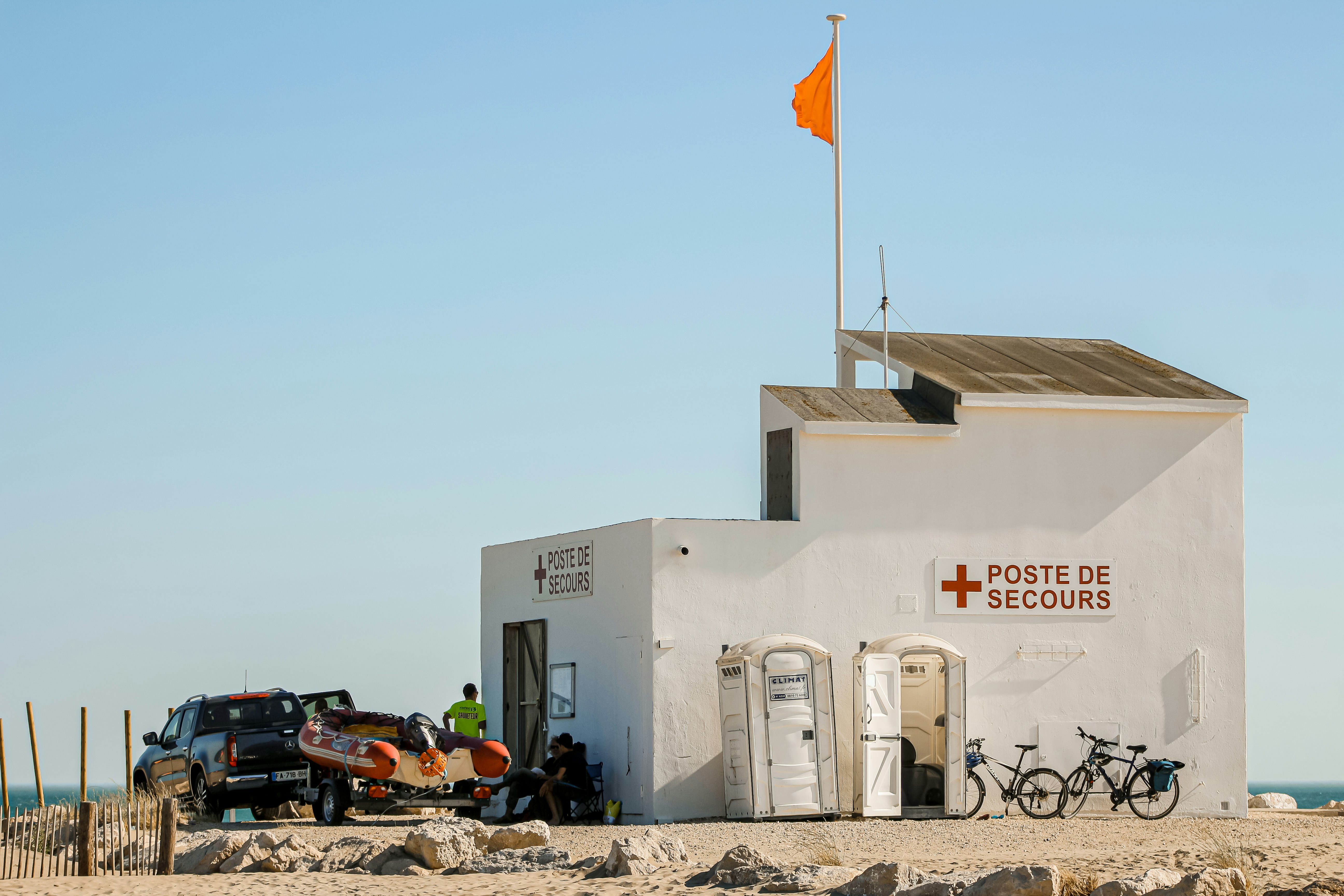 white concrete building with flags on the ground