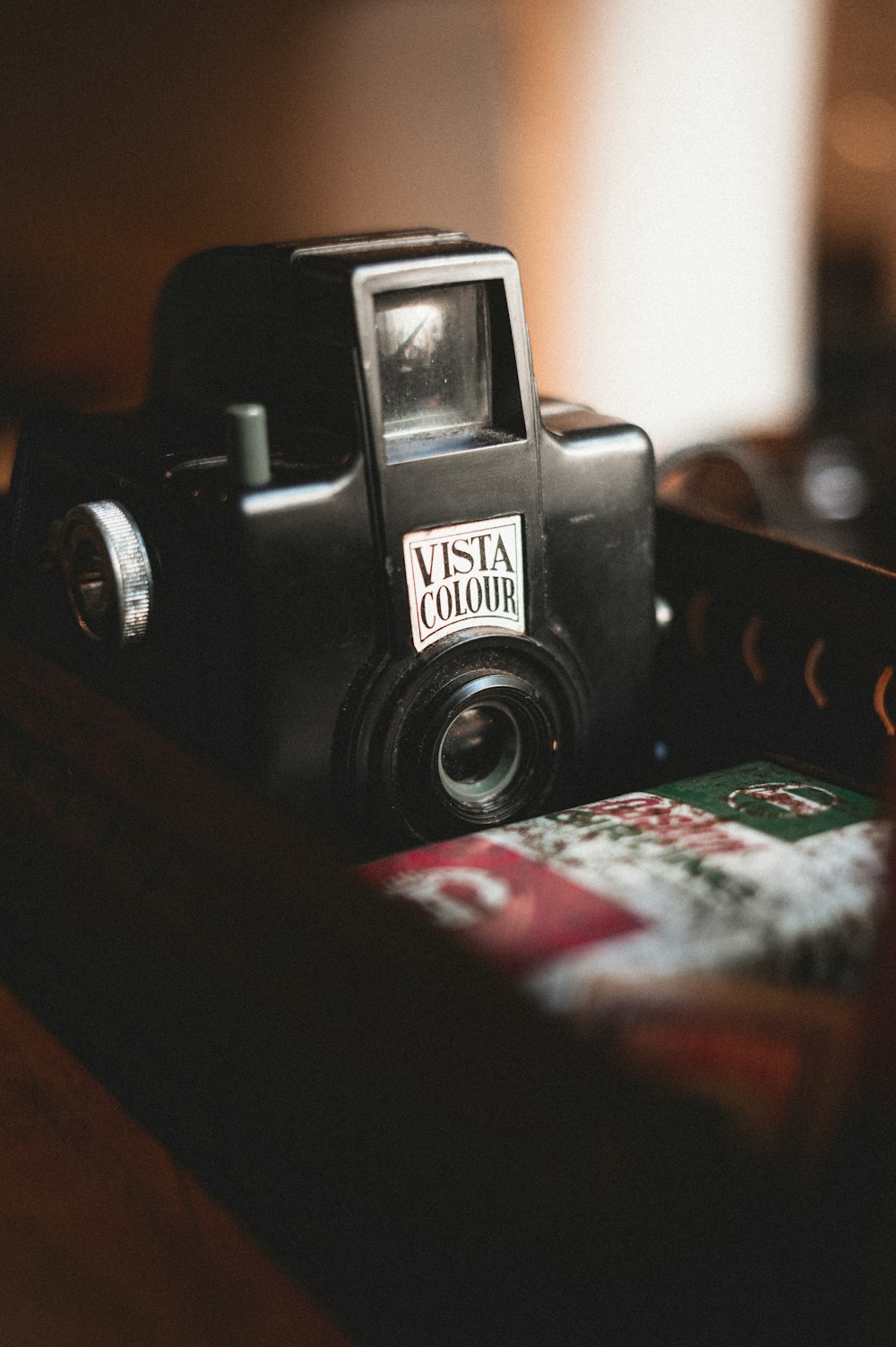 black nikon dslr camera on white and red book