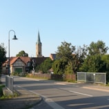 A quiet village scene with simple homes and children playing in the street.
