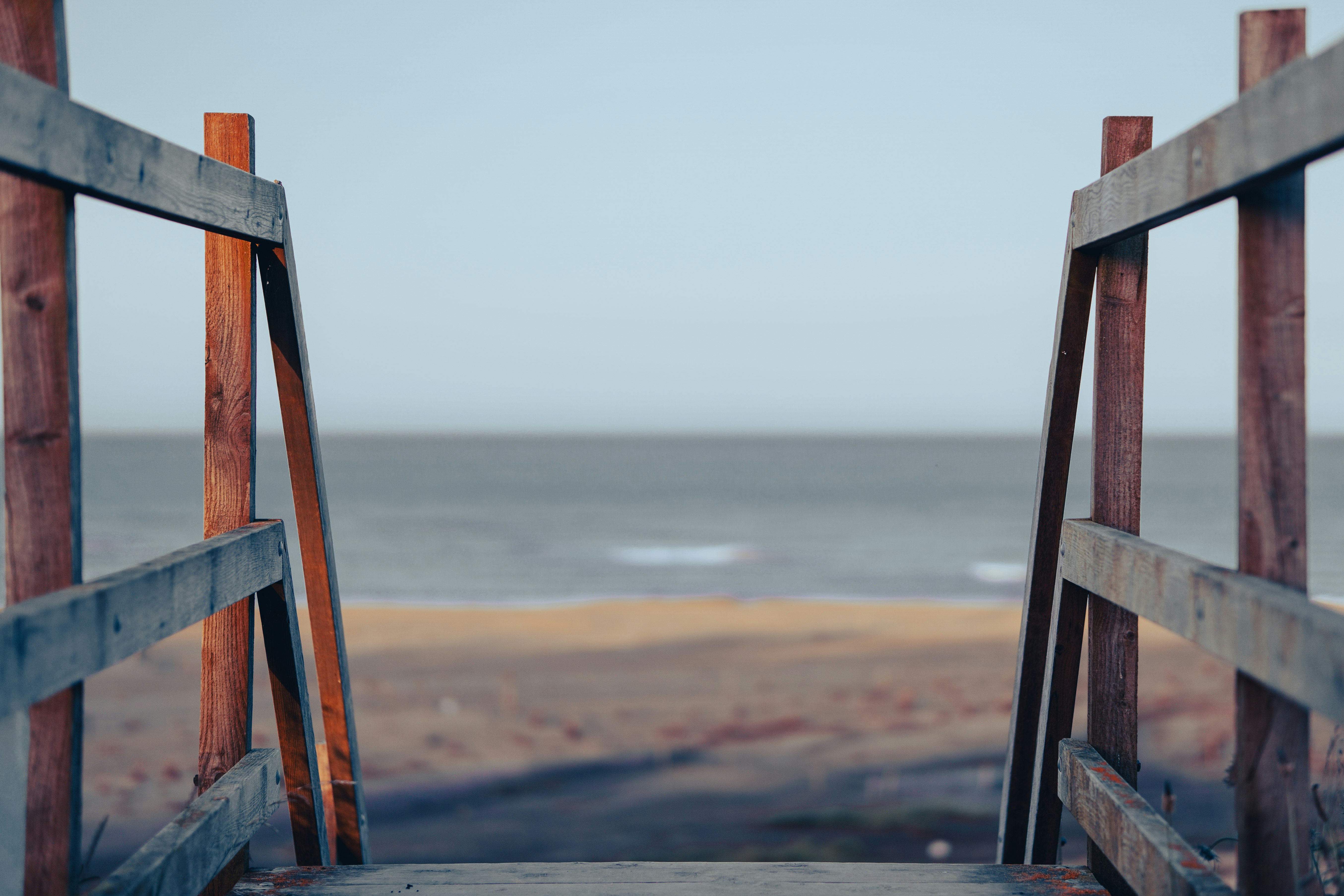 brown wooden fence near body of water during daytime