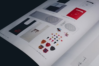 A magazine page featuring various artistic designs including bag templates, colorful geometric shapes, insects, and honeycomb patterns. The artwork is complemented by text in different scripts.