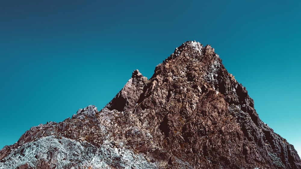 Montagna rocciosa marrone sotto il cielo blu durante il giorno