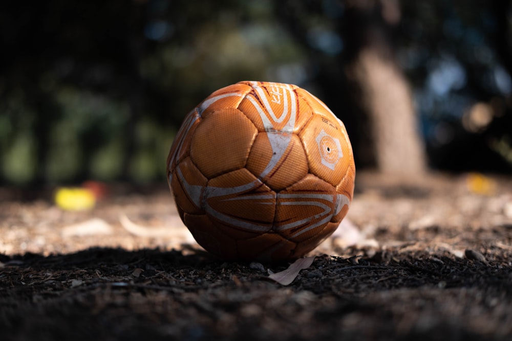orange soccer ball on ground