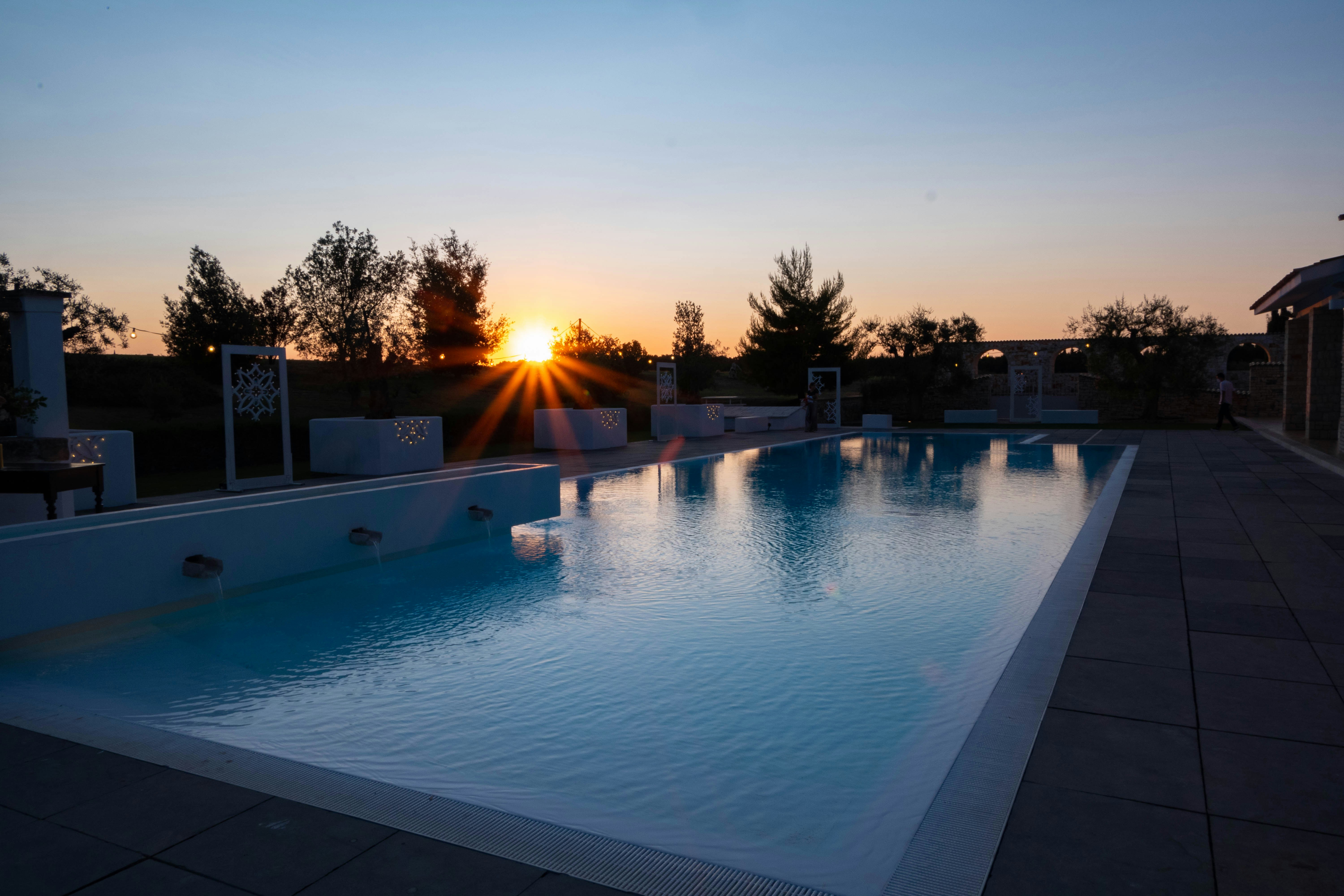 Piscina a sfioro al tramonto con vista panoramica sugli alberi