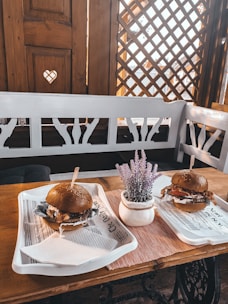 Cozy restaurant interior with customers enjoying freshly made burgers at wooden tables.