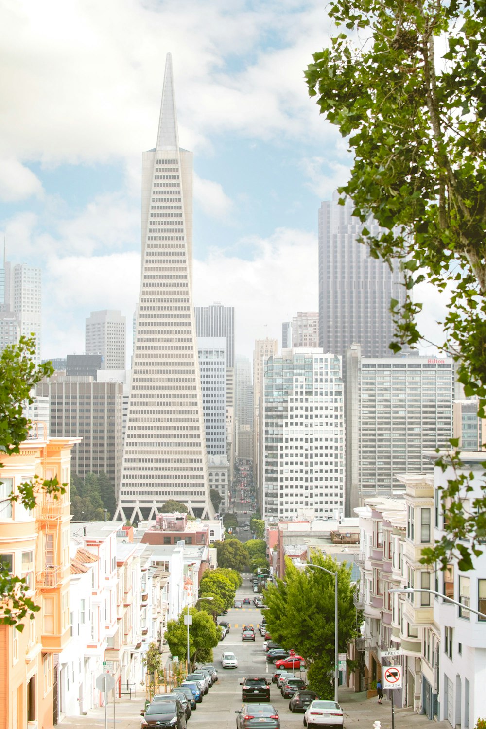 white high rise building near green trees during daytime