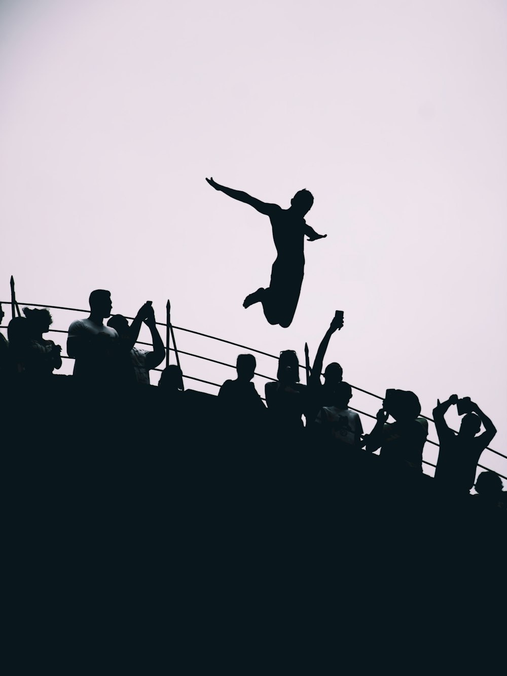 silhouette of people jumping during daytime