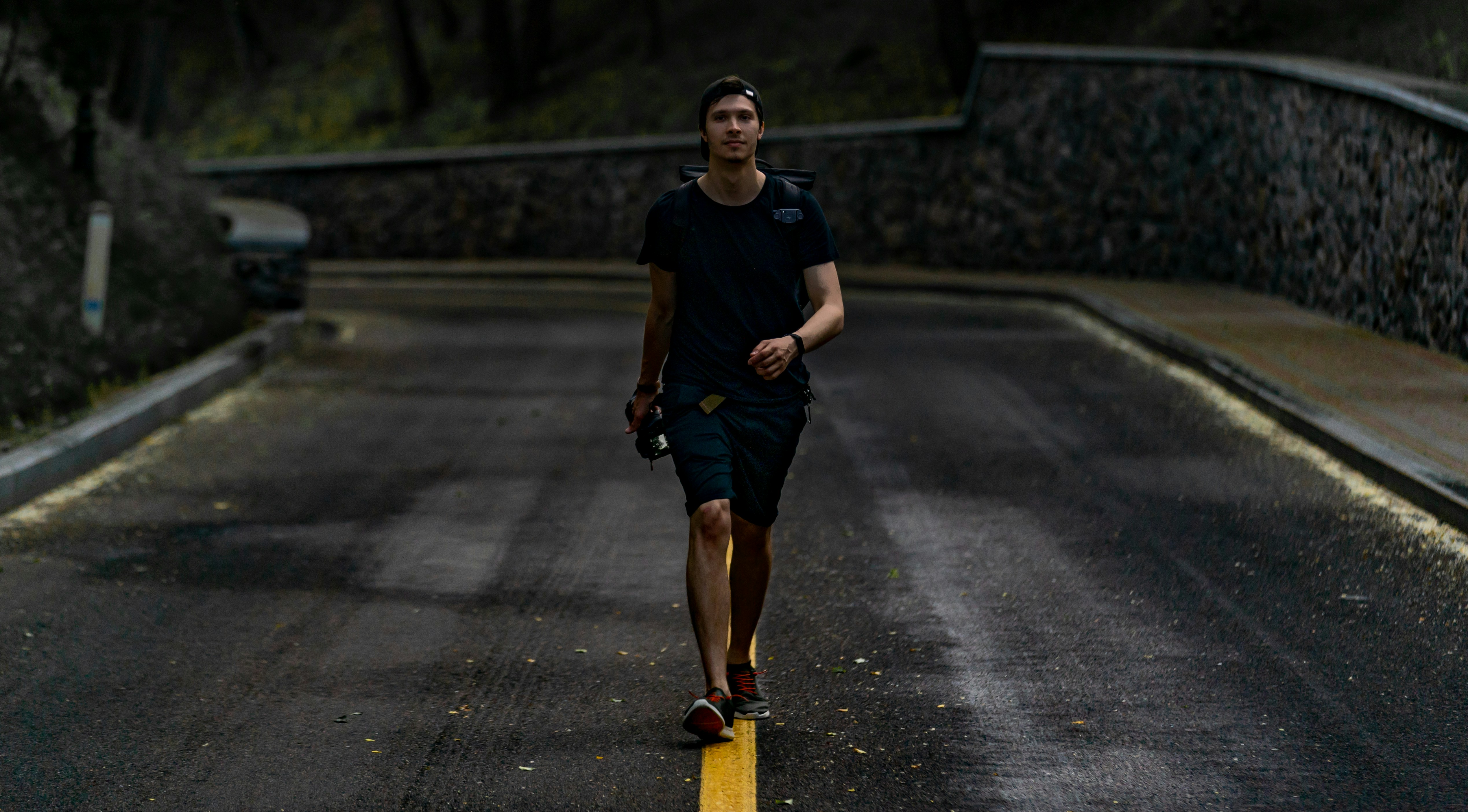 Frau in blauem Rundhals-T-Shirt und schwarzen Shorts, die tagsüber auf der Straße läuft