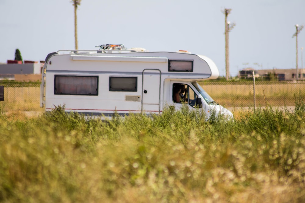 white and brown rv on green grass field during daytime