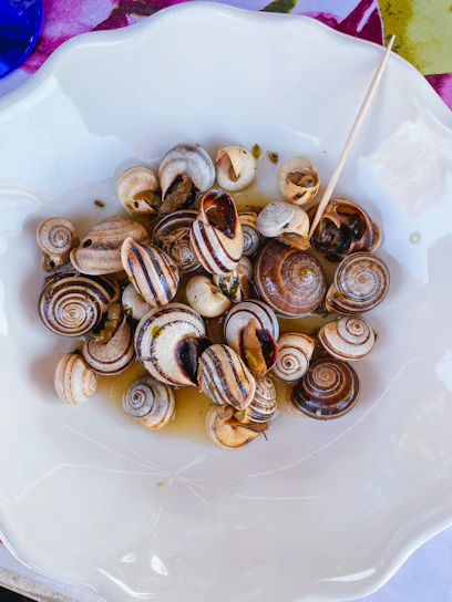 Close-up of fresh snail meat being carefully prepared in a traditional African kitchen.