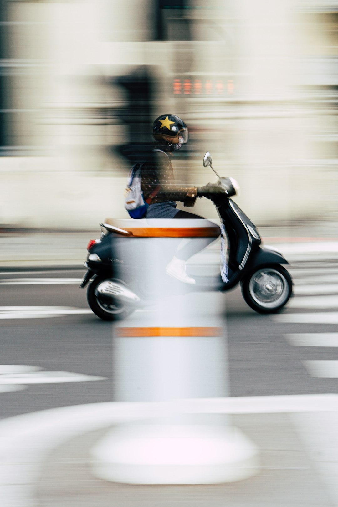man in blue jacket riding on orange and white motor scooter