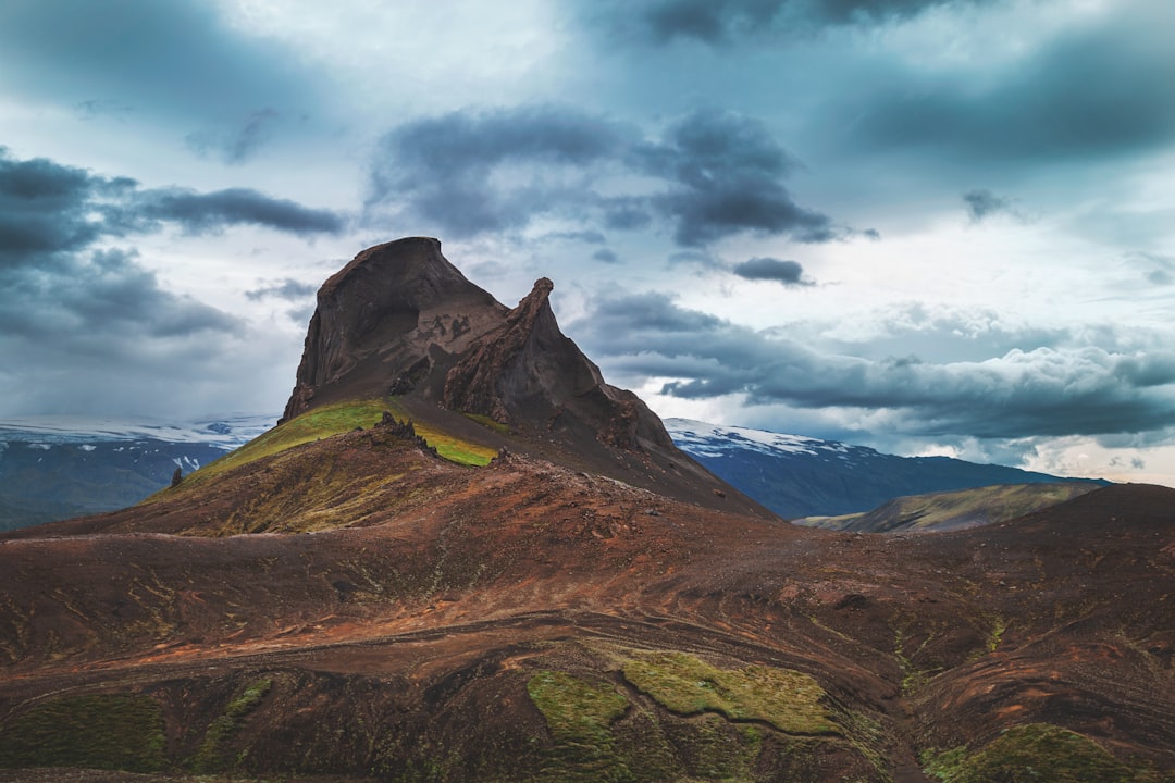 brown and green mountain under white clouds and blue sky during daytime