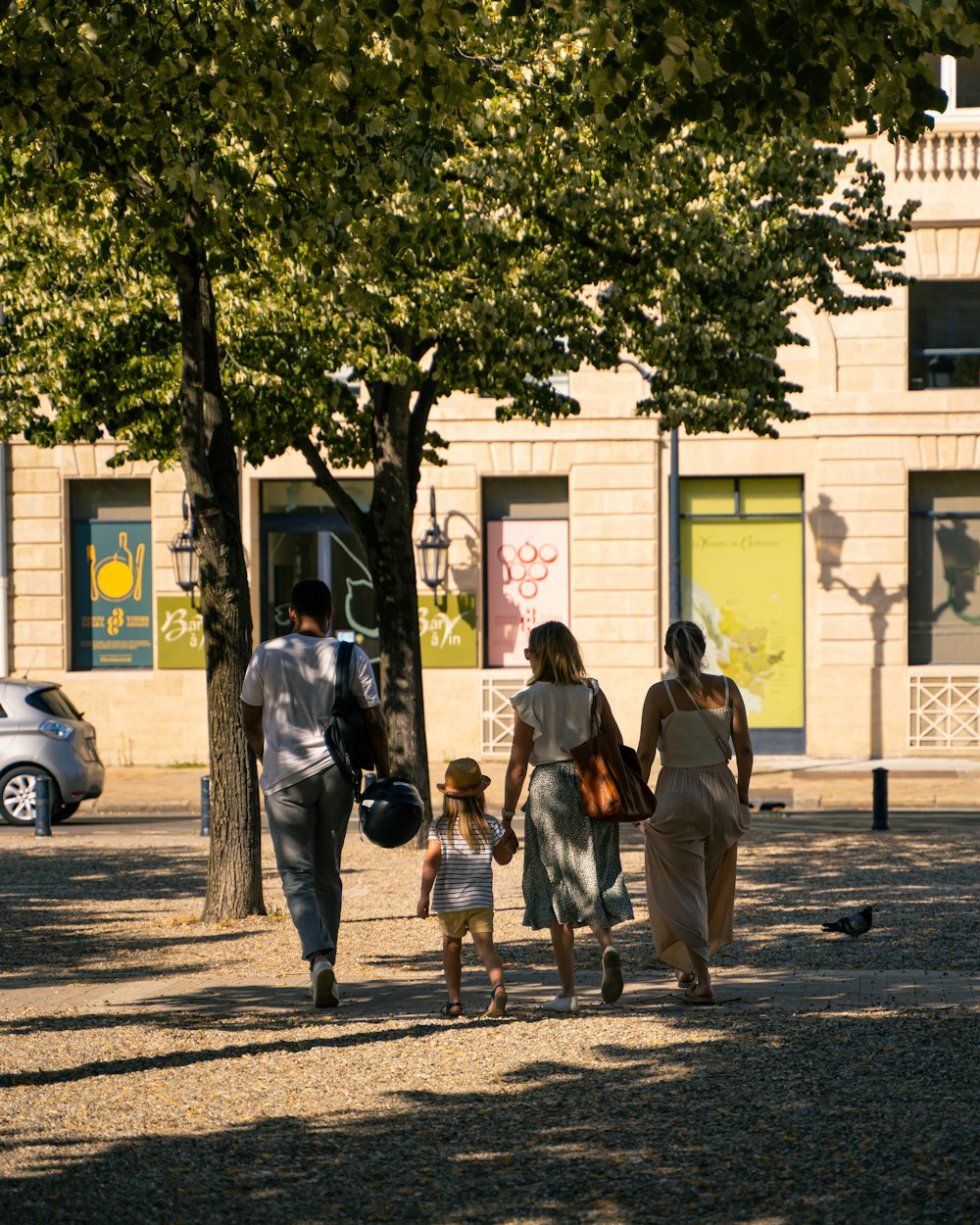 people walking on sidewalk near white building during daytime