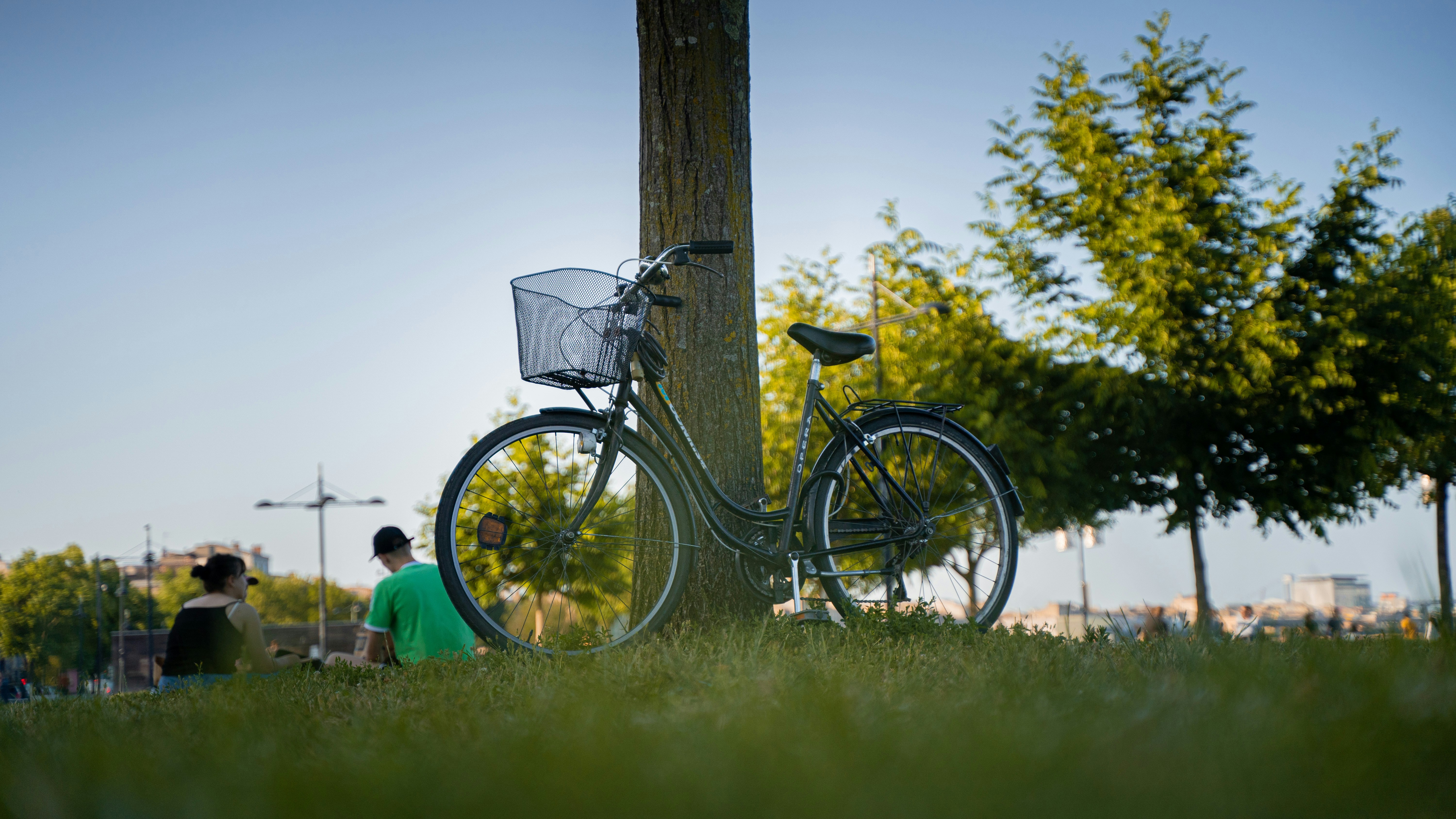bicicleta preta apoiada no poste de madeira marrom durante o dia