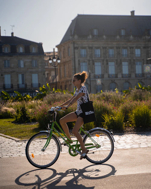 woman in black and white tank top riding on bicycle during daytime