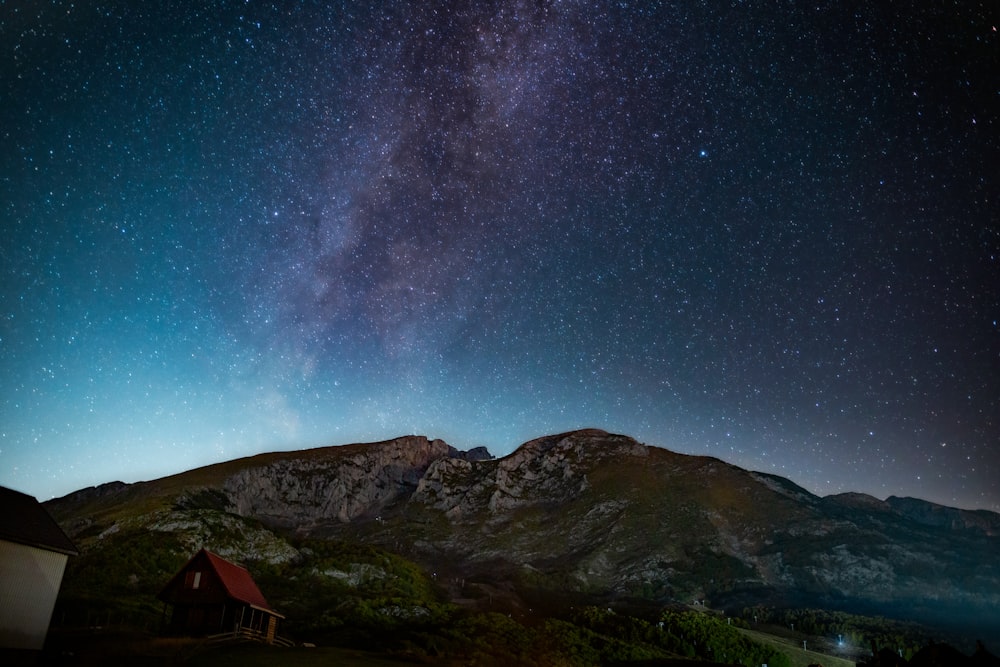 brown and green mountains under blue sky during night time