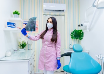 woman in pink long sleeve shirt holding blue and white plastic pitcher