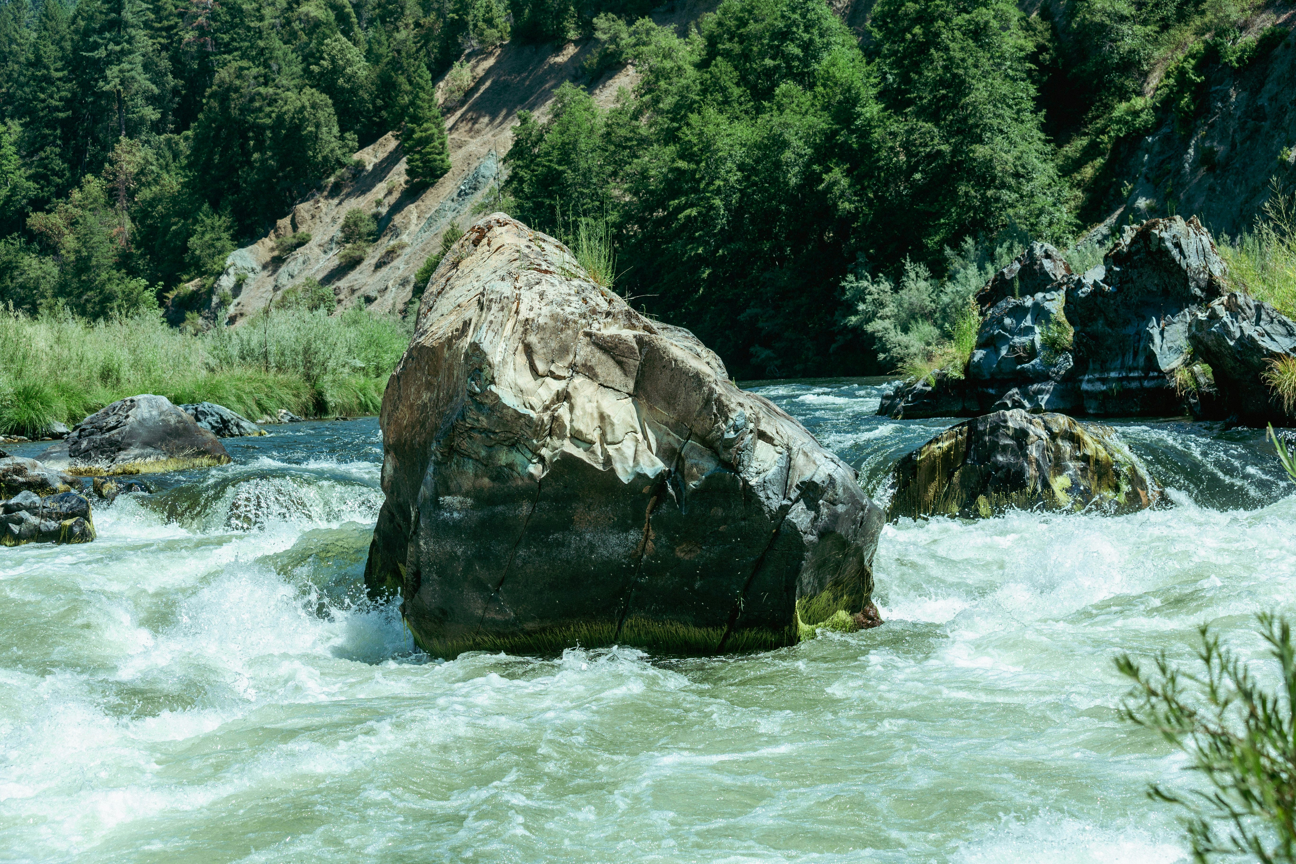 brown rock formation beside river during daytime, 