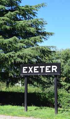 a sign that says exter in front of some trees