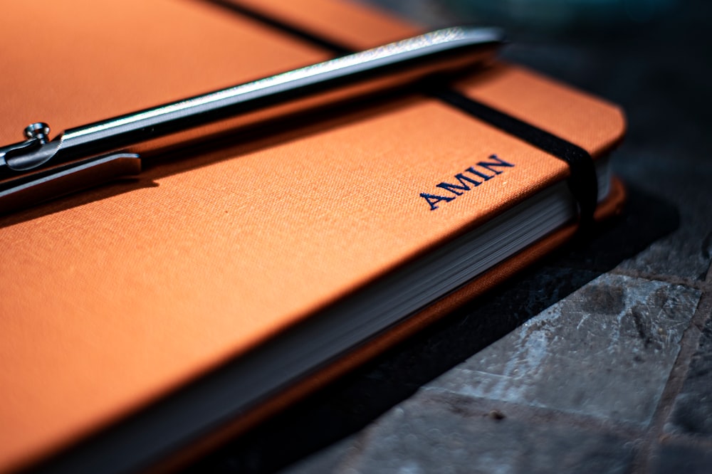 black pen on orange book