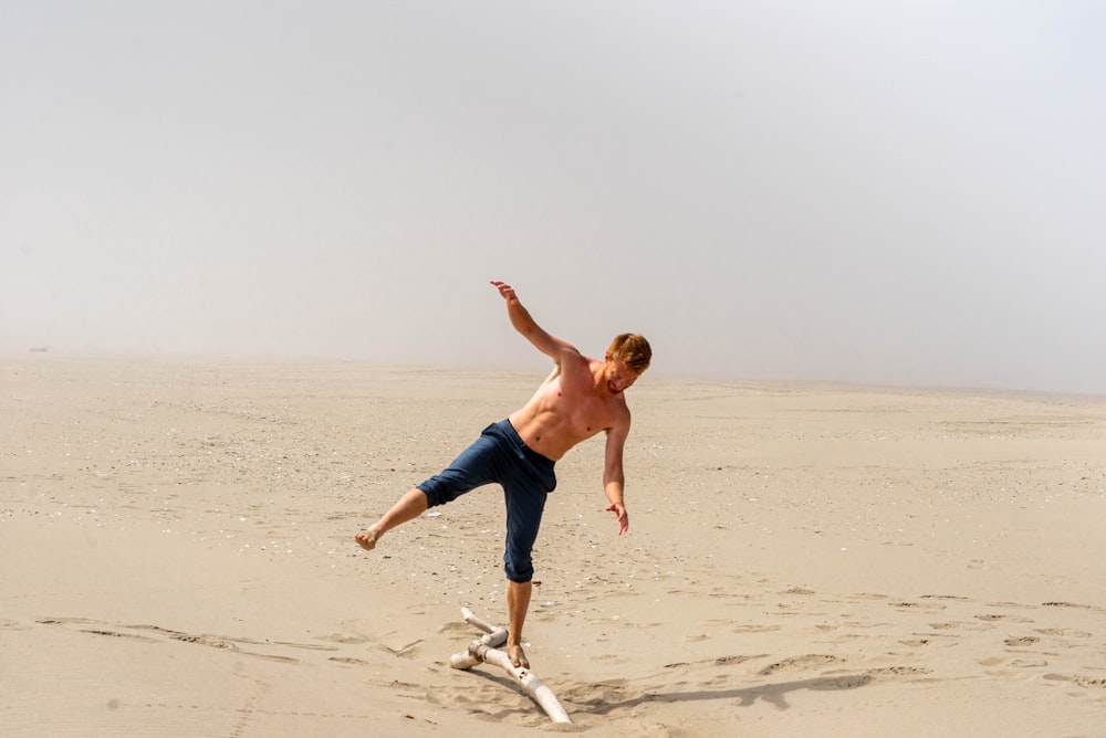 man in blue shorts running on beach during daytime