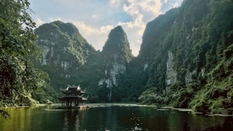 people riding boat on river near mountain during daytime
