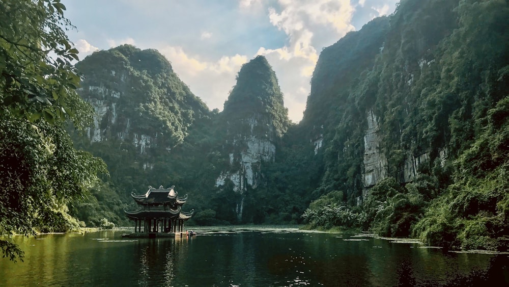 people riding boat on river near mountain during daytime