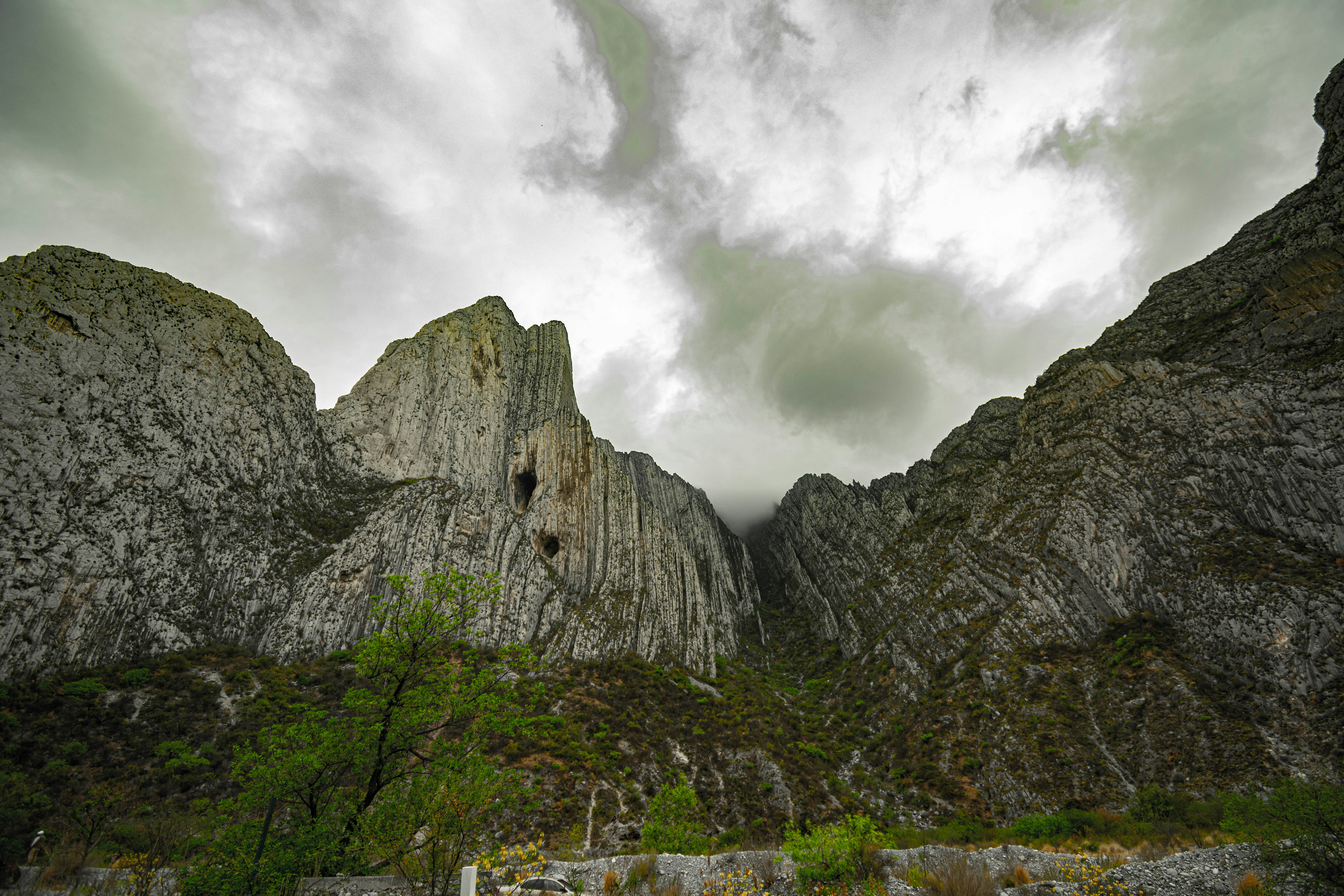 montaña rocosa gris bajo el cielo nublado durante el día