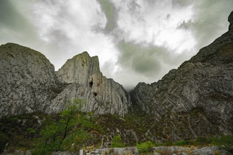 A dramatic shot of rugged alpine cliffs under a moody sky, showcasing Europe’s natural grandeur.