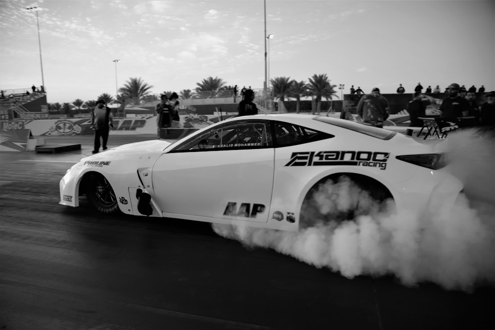 grayscale photo of white and red racing car