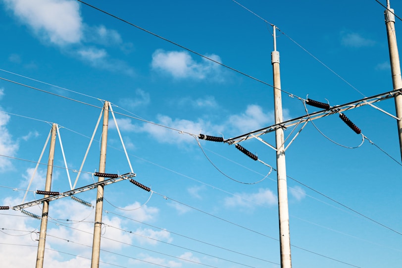 brown electric post under blue sky during daytime