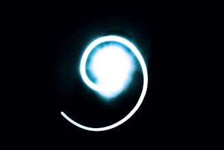 Glowing spinning wheel surrounded by sparkling magical symbols on a dark background.