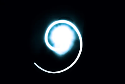 Glowing spinning wheel surrounded by sparkling magical symbols on a dark background.