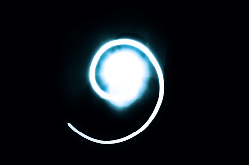 A glowing helix of light spiraling through a cosmic nebula.