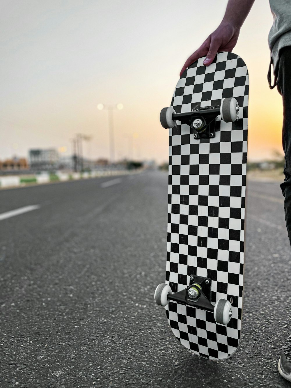 black and white checkered luggage bag on gray asphalt road during daytime