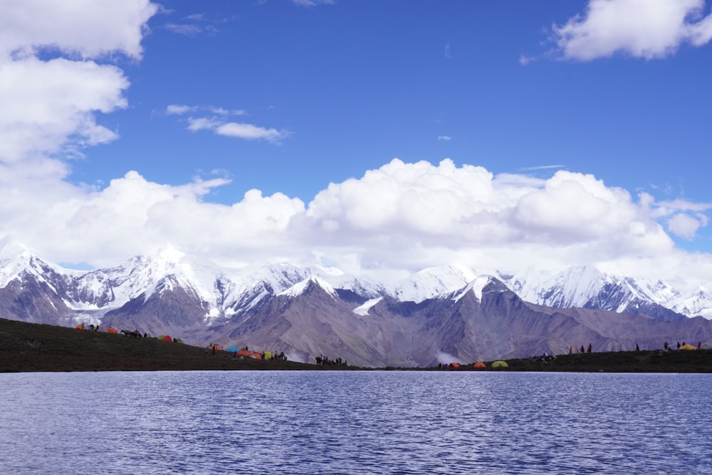 body of water near mountain under blue sky during daytime