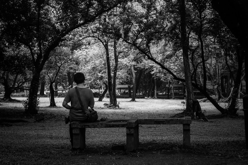 2 person sitting on bench in grayscale photography