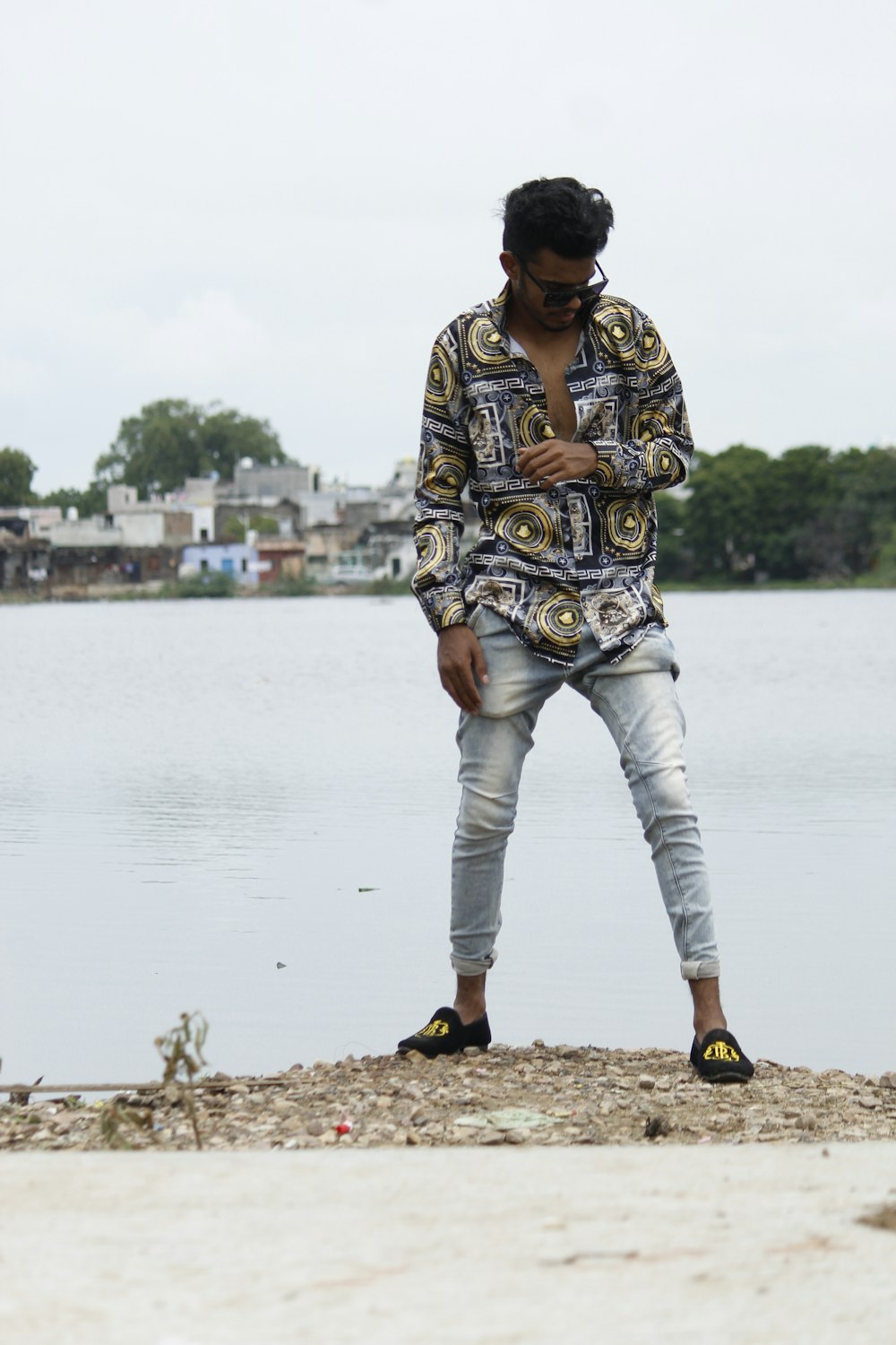 woman in brown and black floral long sleeve shirt and white pants standing on brown field