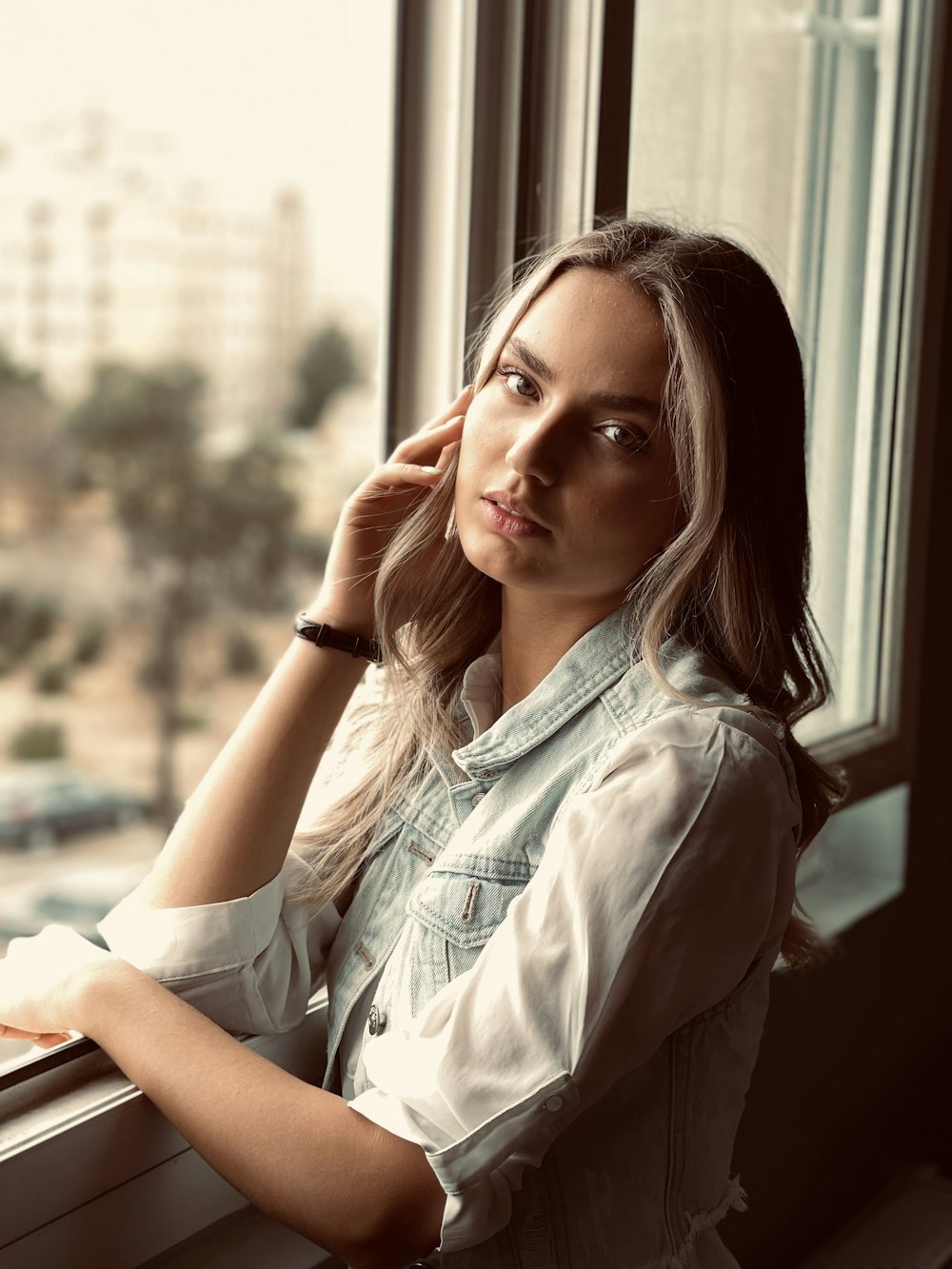 woman in white button up shirt leaning on brown wooden table