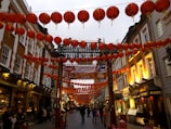 A vibrant street scene decorated with red lanterns and festive banners for Chinese New Year.