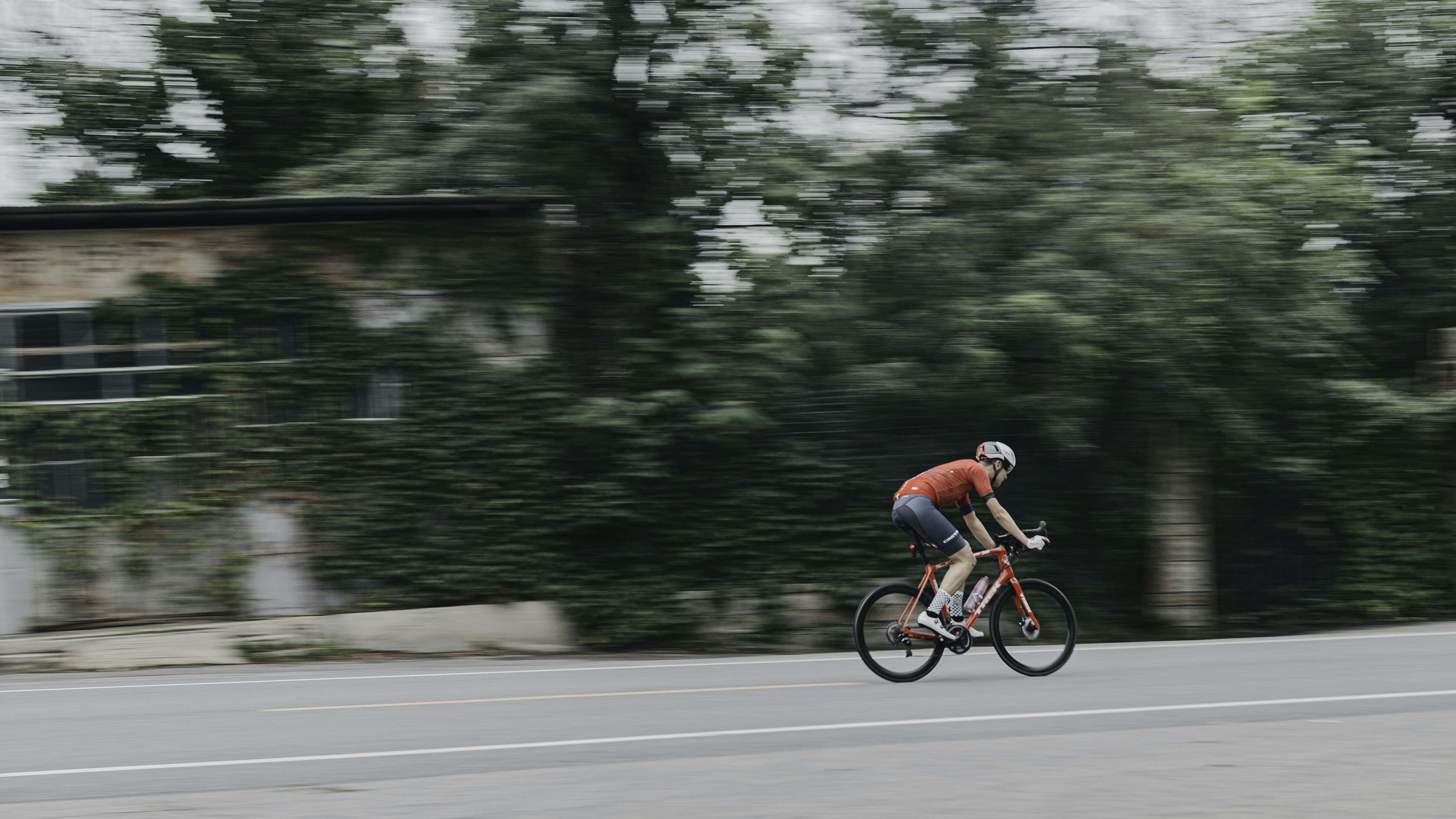 man in red shirt riding bicycle on road during daytime