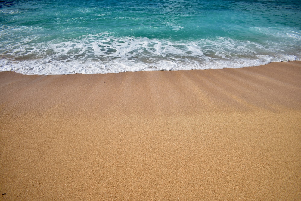 sea waves crashing on shore during daytime