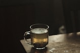 clear glass mug with brown liquid