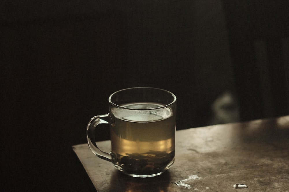 clear glass mug with brown liquid