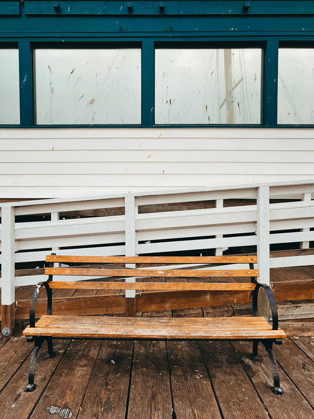 brown wooden bench beside blue and white wall