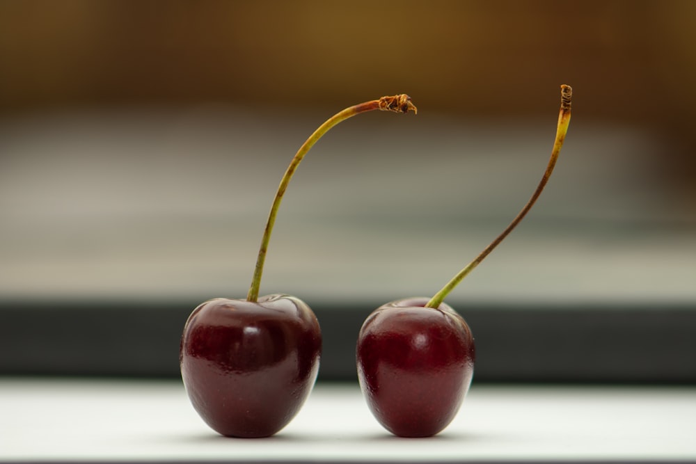 2 red cherries on white table