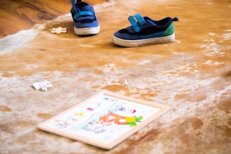 blue and black nike sneakers on brown and white floor